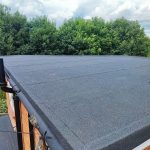 High-performance three-layer felt flat roof replacement with new OSB decking, lead flashings, and drip trims.
